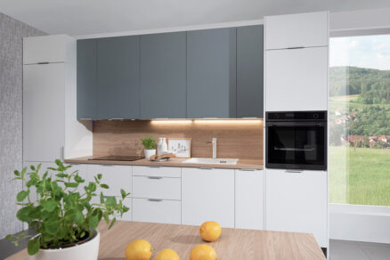 Kuchyňa z konceptu HOME. Predné plochy biela arctic matná a monumentálna sivá. Koncept lineárnej kuchyne s vysokými hornými skrinkami so zväčšeným úložným priestorom.
