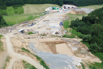 Obr. 2 Pohľad na rozpracovaný úsek stavby v km 4,3, budovanie násypu, v strede zľava mostné objekty 218-00 a 204-00, v pozadí západný portál tunela Okruhliak