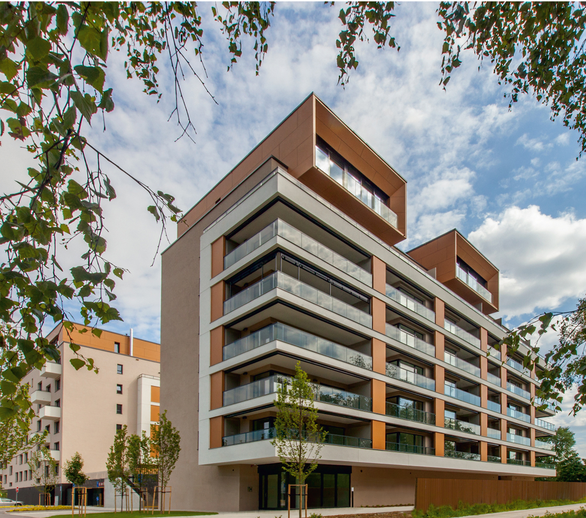 Moderný bytový komplex s balkónmi a zeleným okolím, navrhnutý pre mestské bývanie.