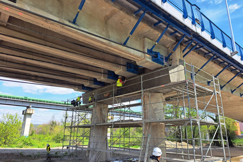 Práce na pilieroch mosta počas rekonštrukcie, s použitím lešenia a moderných materiálov Mapei.